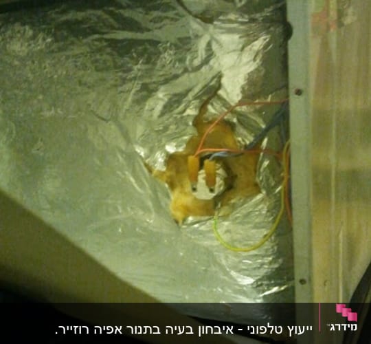 חוטי חשמל צבעוניים מחוברים לשקע על רקע מתכתי